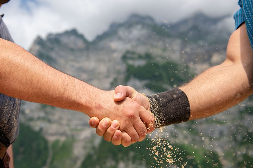 Handshake zwischen zwei Schwingern im Sägemehl