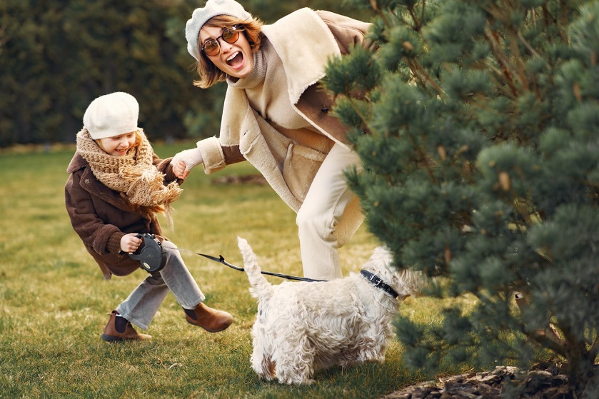 Frau mit Kind und Hund im Garten