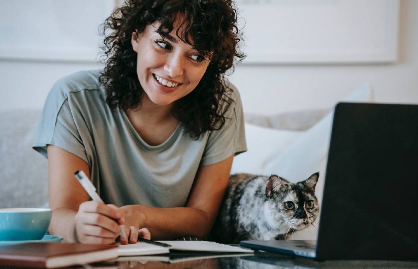 Frau mit Katze am Laptop