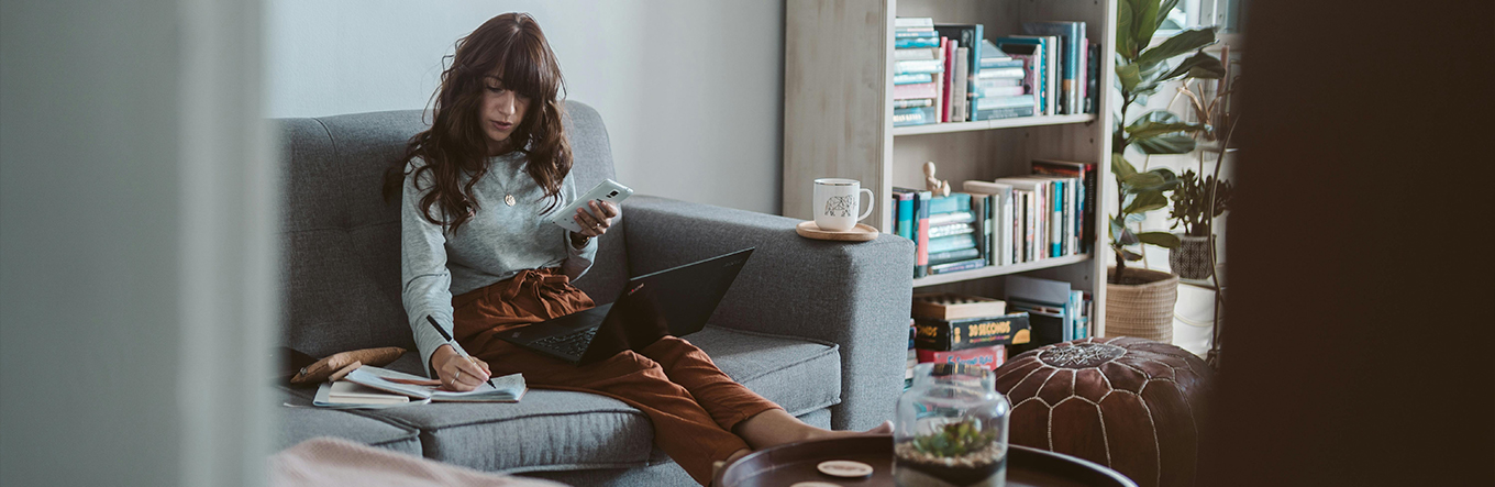 Person mit Rechner auf dem Sofa